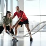 A Woman Holding Ropes Beside a Trainer